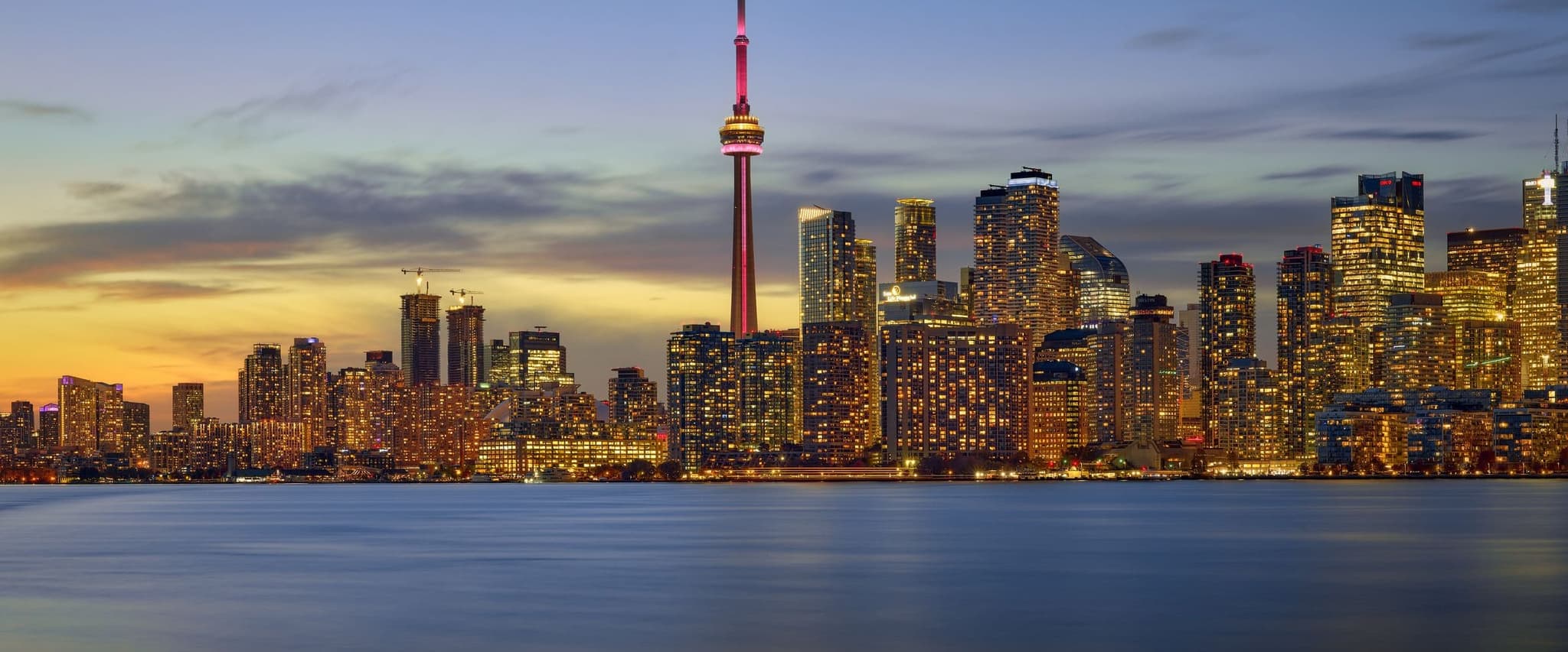 Toronto skyline and CN Tower across Lake Ontario at dusk