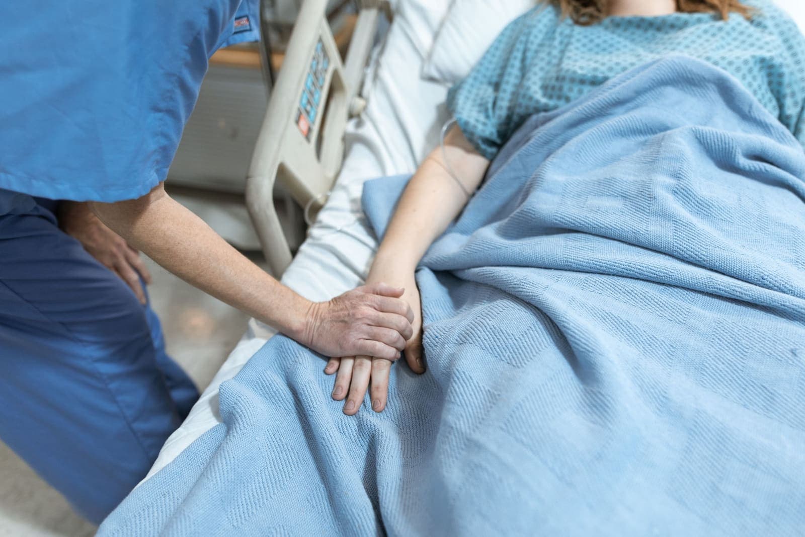 Healthcare professional holding a patient's hand